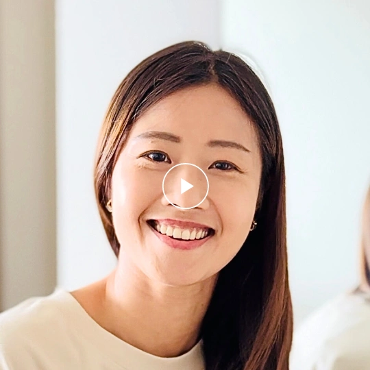 An executive team member, a woman in her 30s, exuding warmth with a gentle smile.